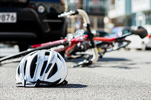 a bicycle lies on ground beside helmet