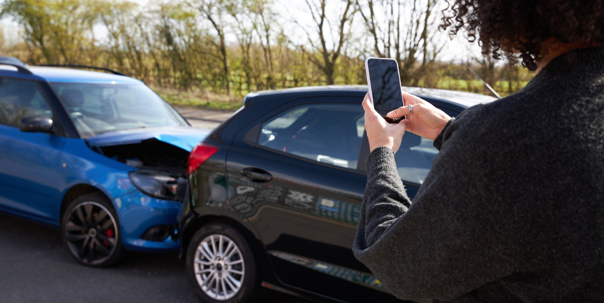 a woman takes a photo of a car accident