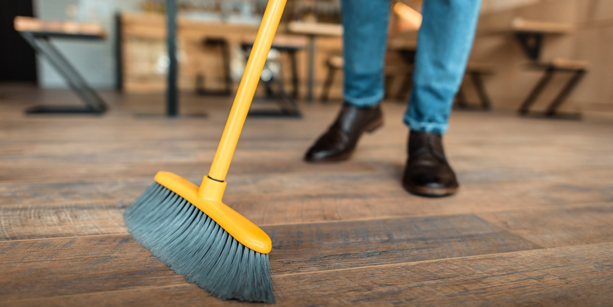 worker sweeping with broom